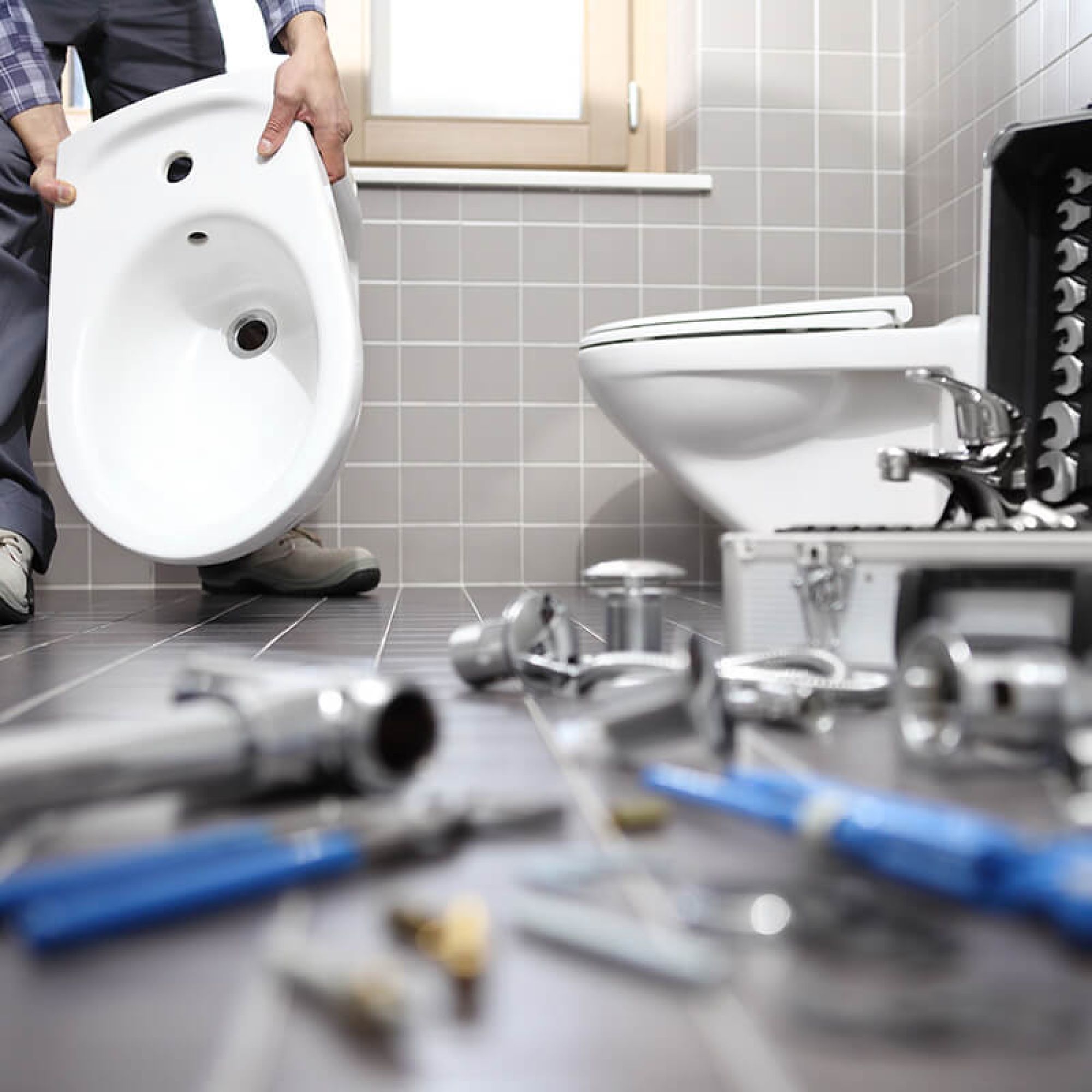 Monteur tauscht Toilette im Badezimmer aus